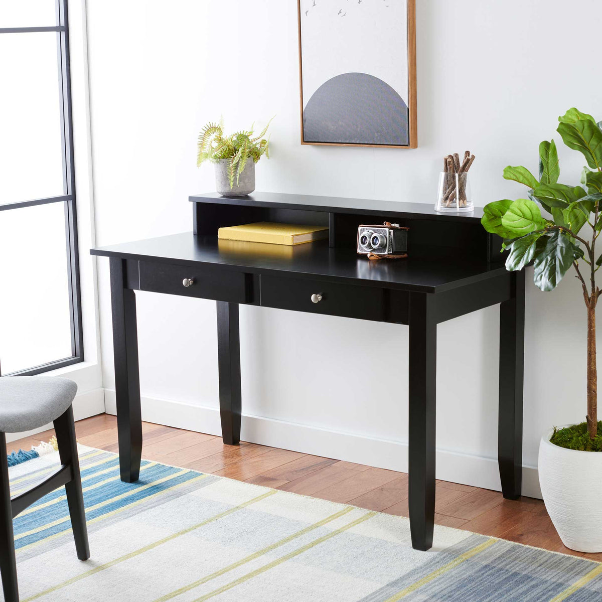 Two drawers and open upper storage keep essentials within reach on this matte black desk