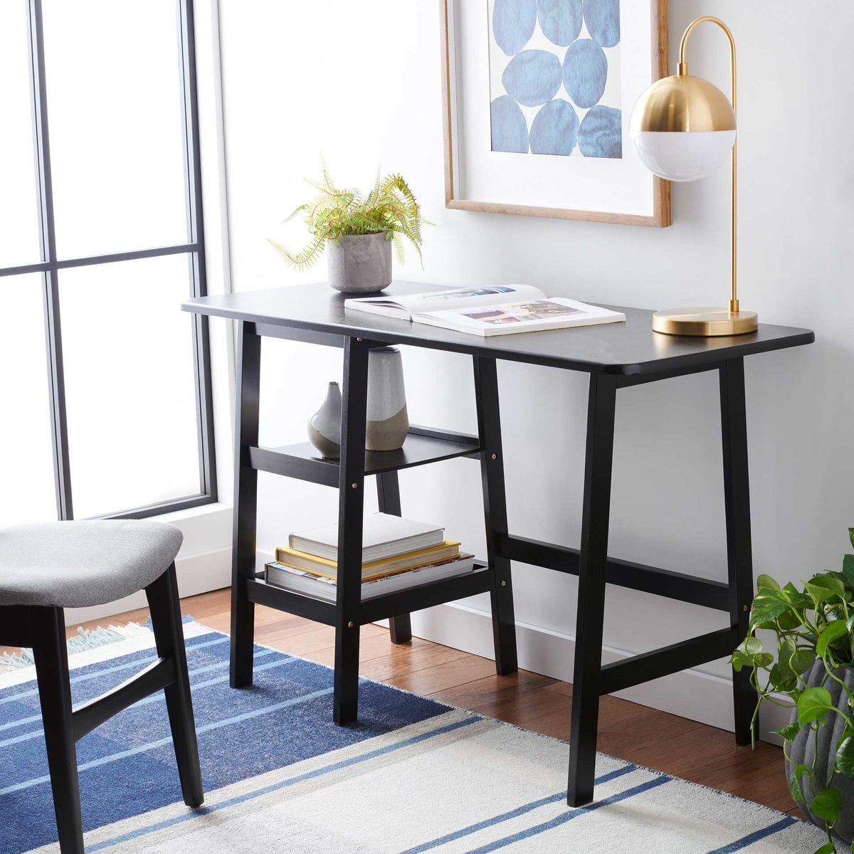 Two open shelves keep books and decor handy beneath a matte black work surface.
