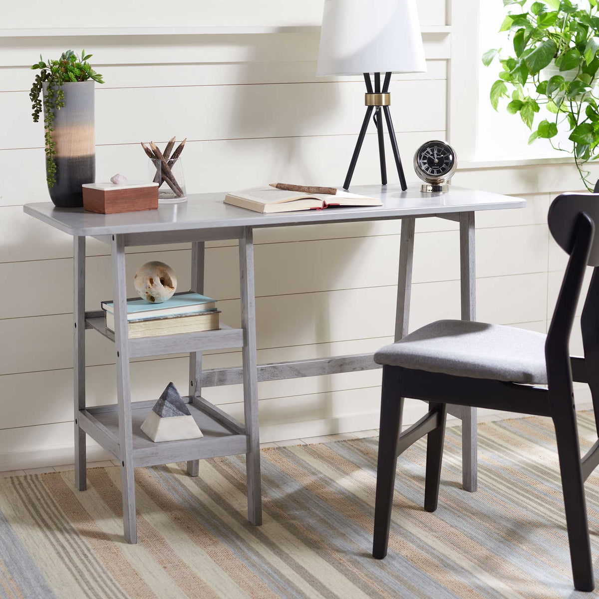 Open gray shelving keeps books and decor close to a spacious desktop.