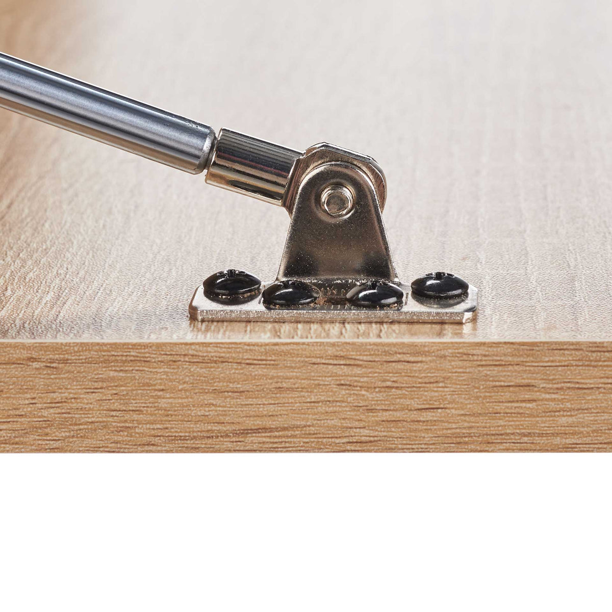 A silver support strut meets a screwed hinge on the natural wood-look fold-down surface.