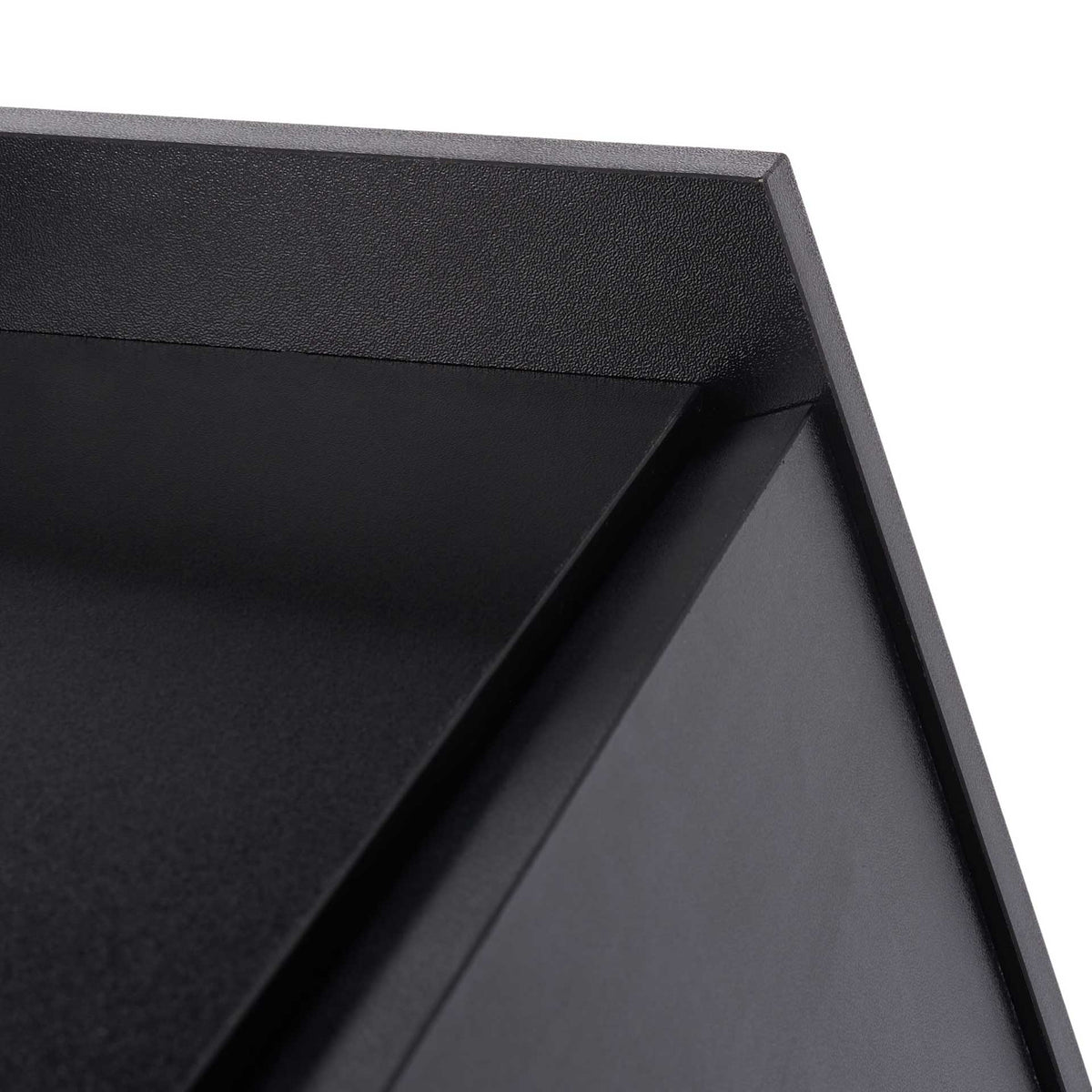 Fine black texture and crisp angled edges finish the desk's raised upper ledge.
