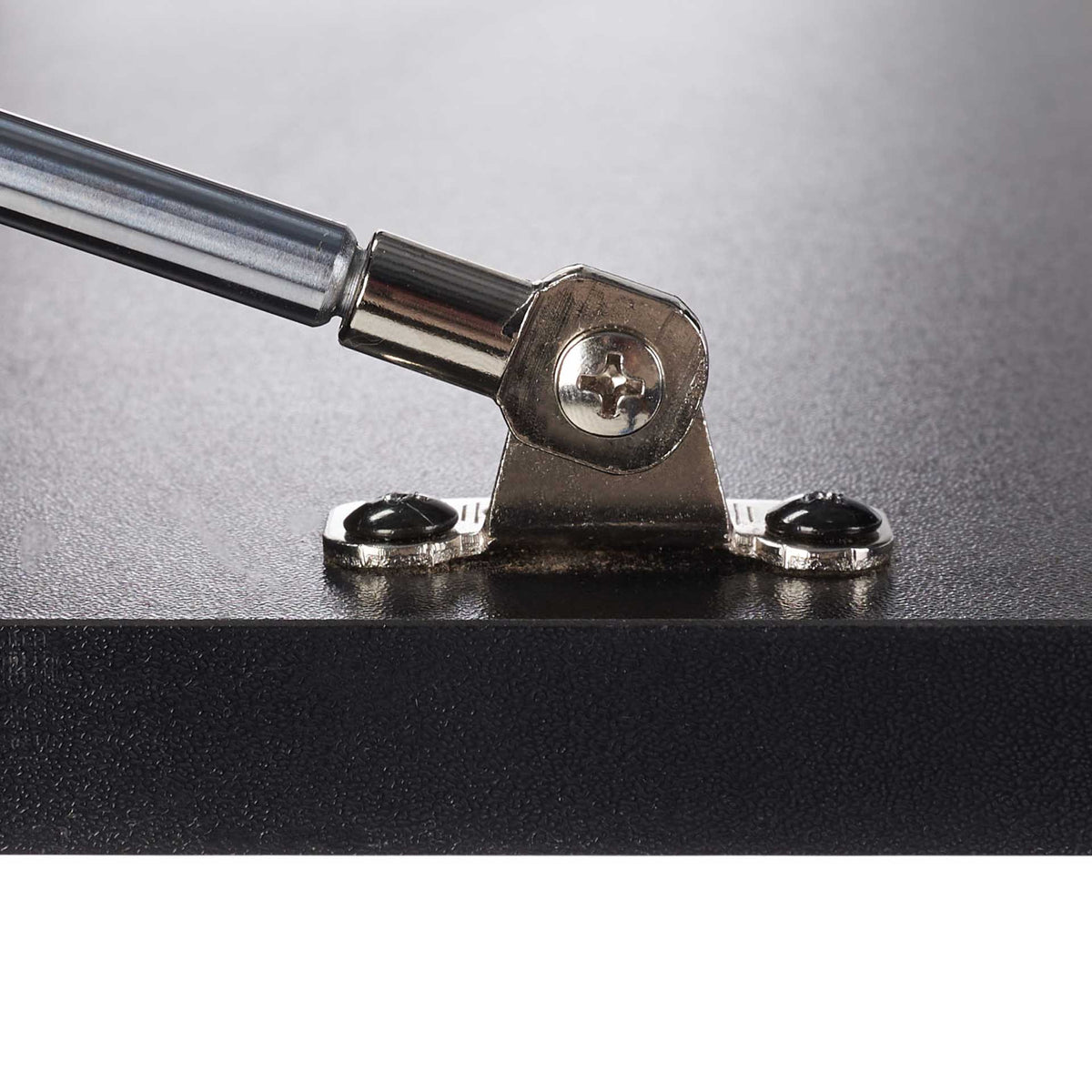 A polished metal hinge and support strut secure the black fold-down desktop.