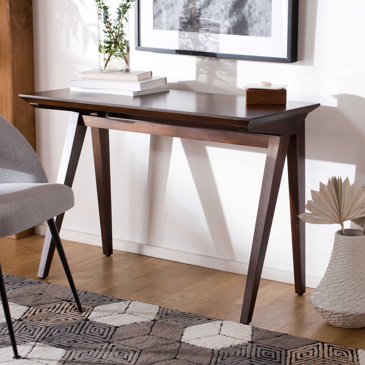 A dark walnut desktop and angled wood legs create a warm, streamlined workspace.