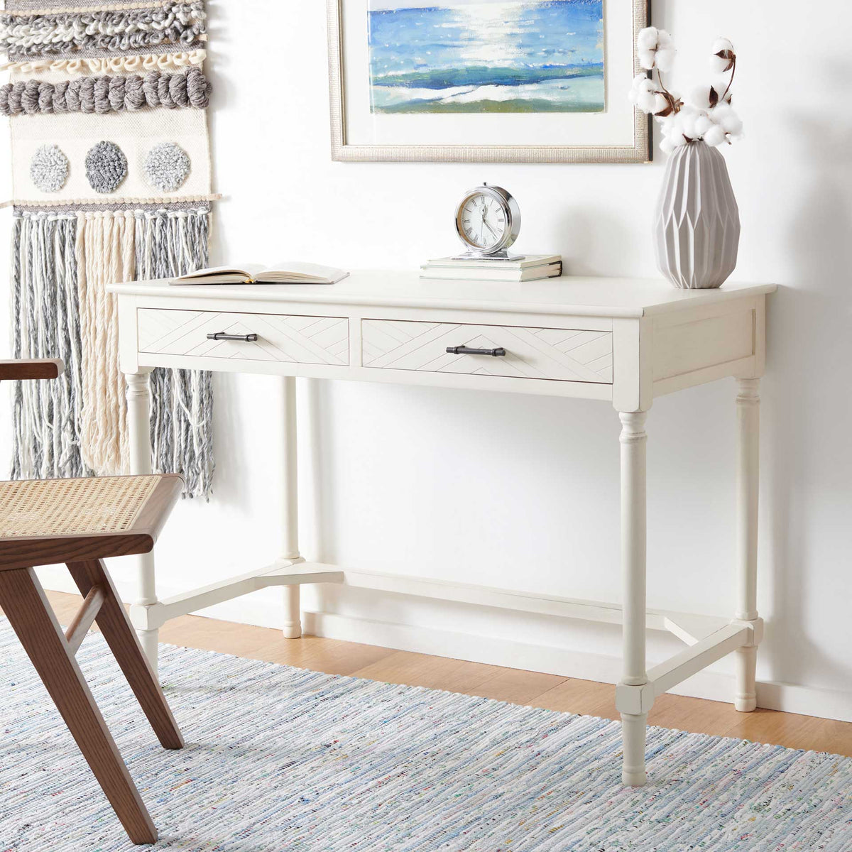 Crisp white writing desk brings chevron detail, dark handles, and turned legs to a bright space