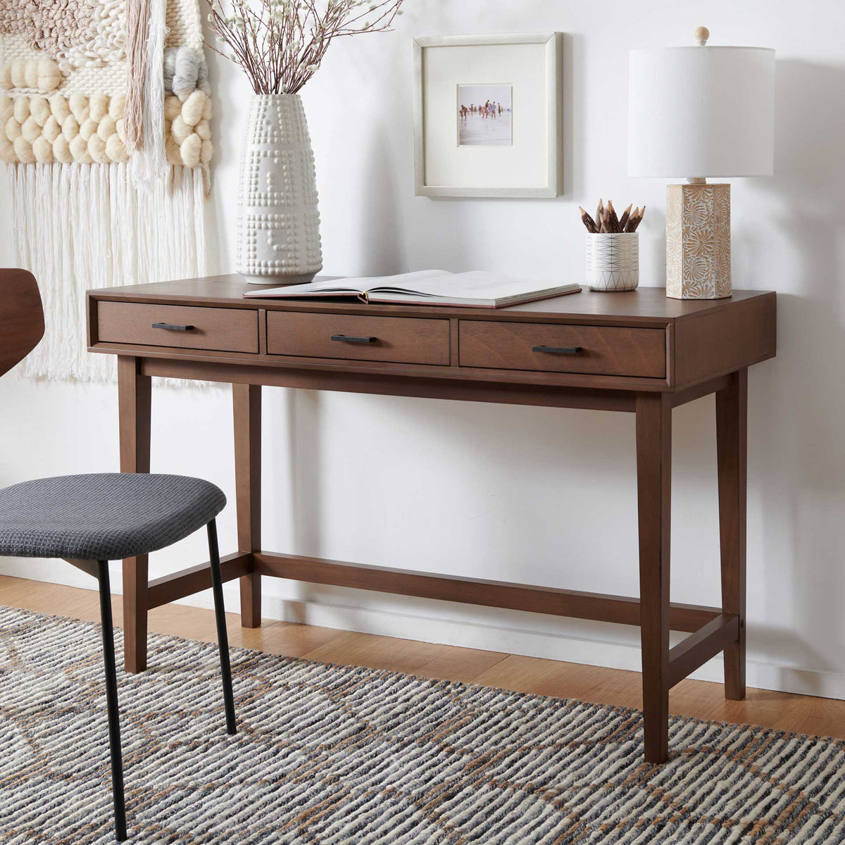 Warm brown finish and three storage drawers bring style and function to a home workspace