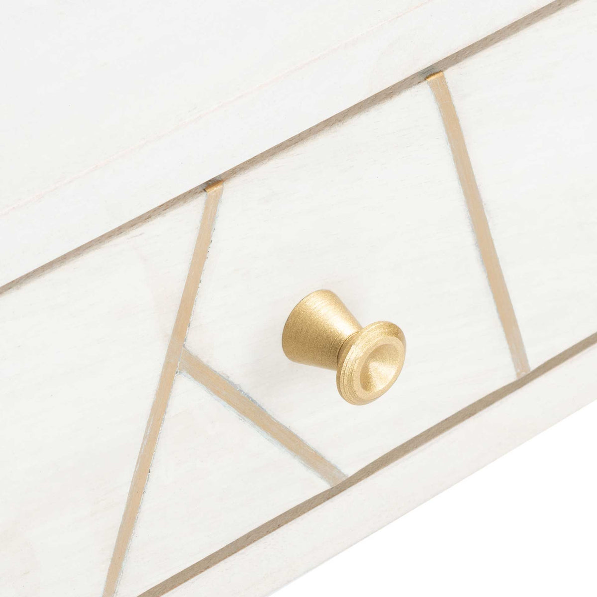 A rounded brass-tone pull complements the fine geometric inlay on the whitewashed drawer