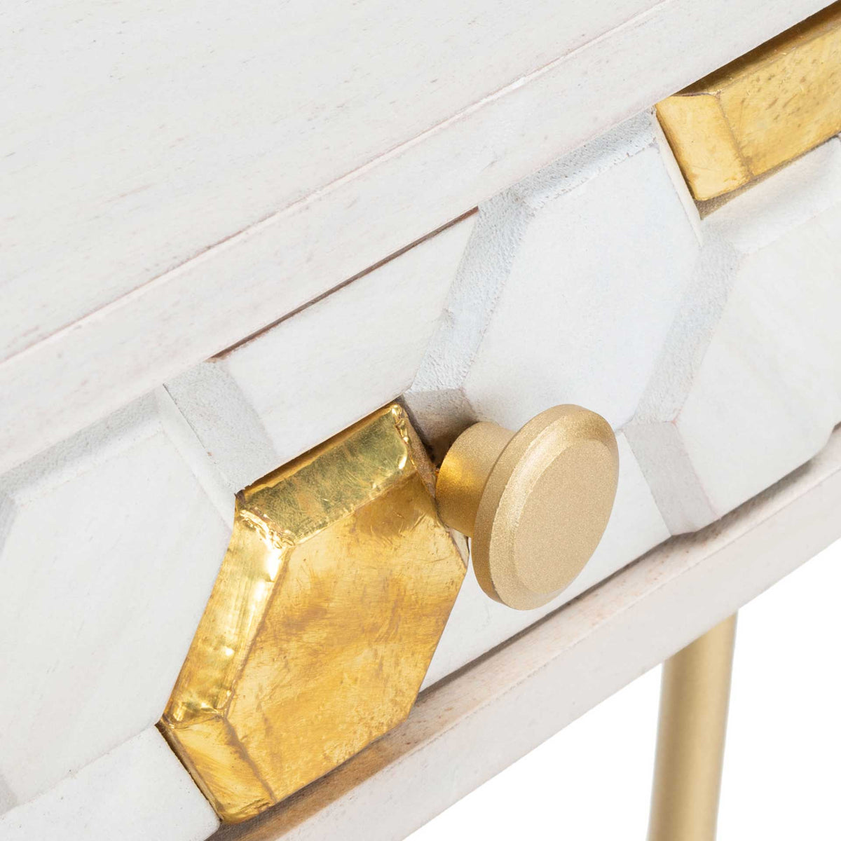 A round brass pull complements raised honeycomb carving and gleaming brass accents.
