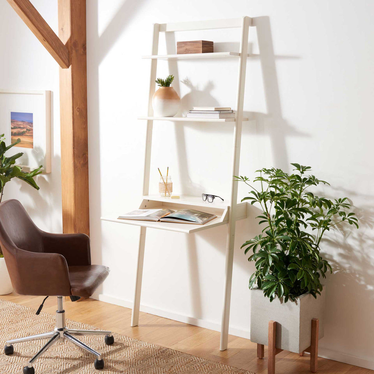 A bright white workspace sits below open shelves styled with books and small decor.
