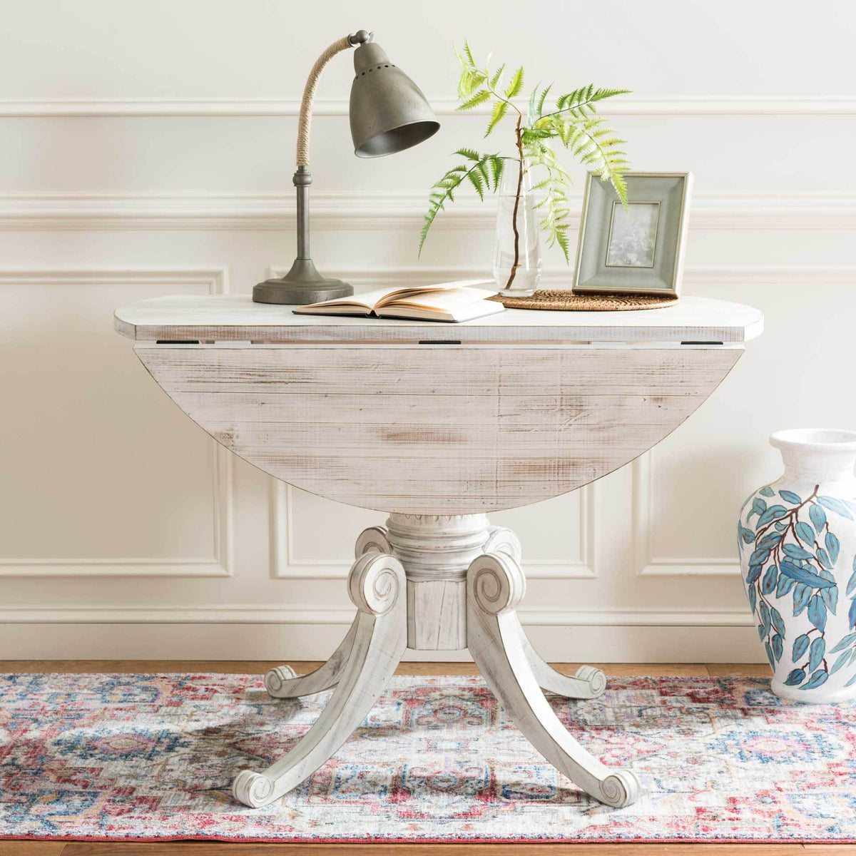 Lowered leaves give this antique white pedestal table a slim profile for compact spaces