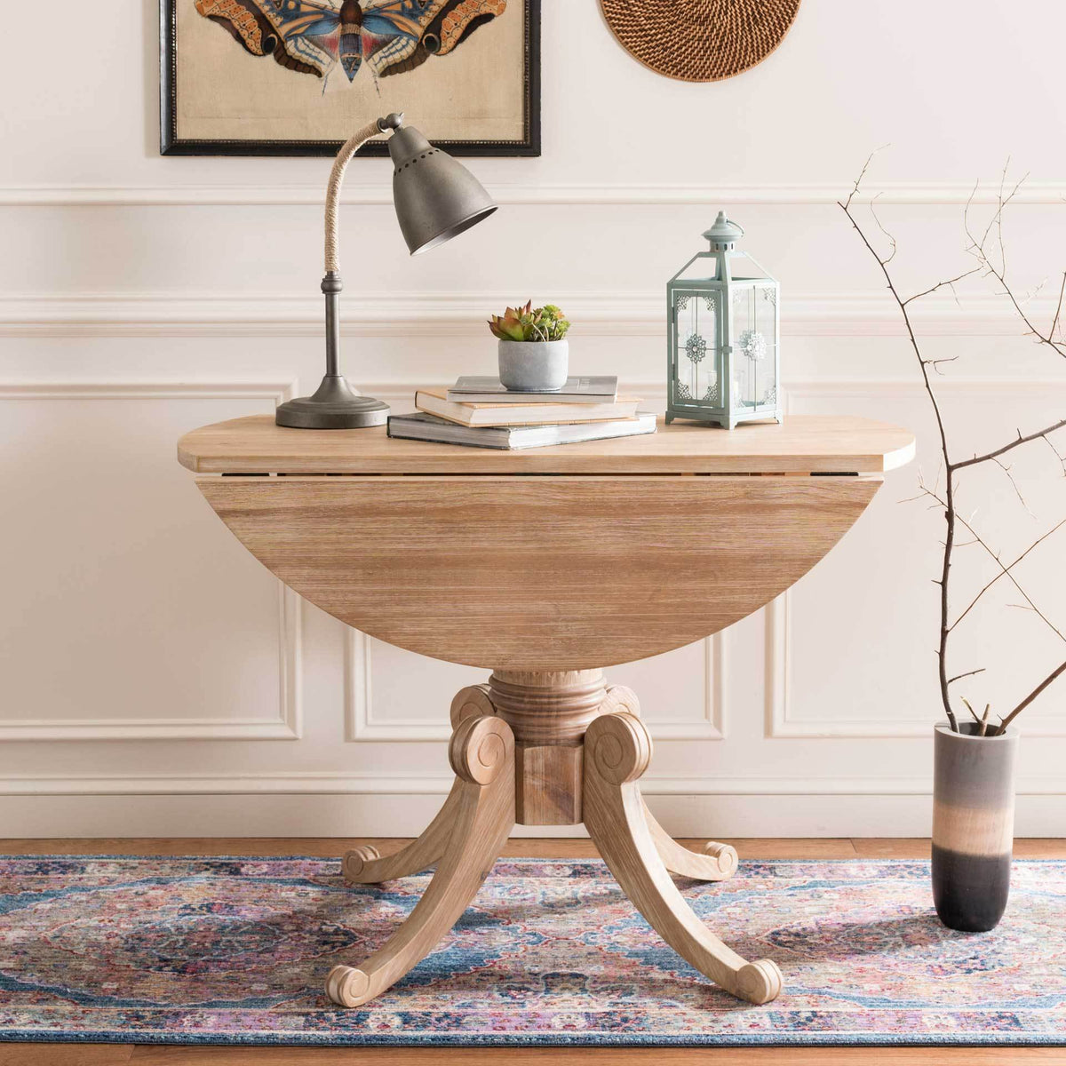 Both leaves fold down to give the natural wood pedestal table a slim, space-saving silhouette