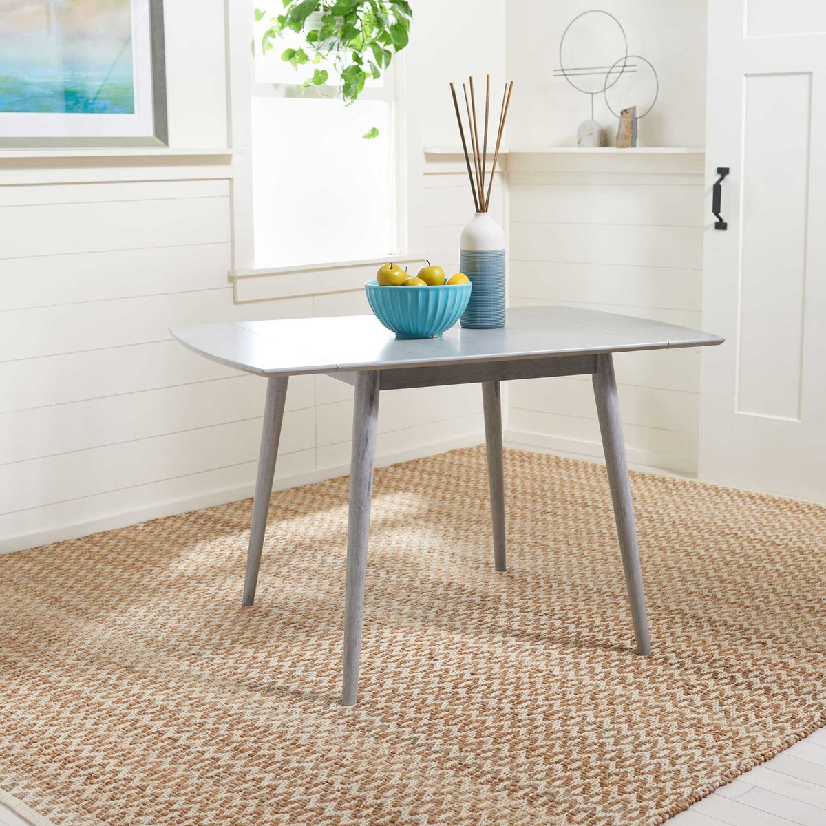 Open drop leaves give this gray wood dining table a generous surface on slender, angled legs