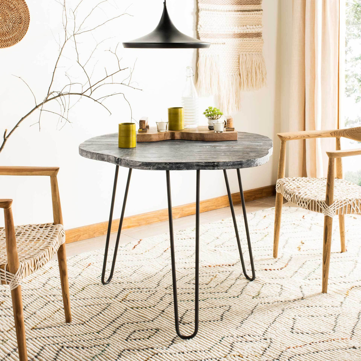 Weathered wood dining table combines a rounded top with slender black hairpin legs