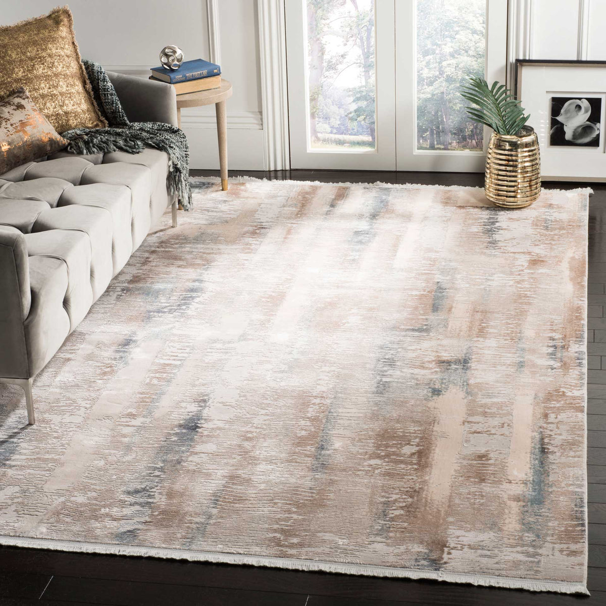 A softly distressed beige and cream rug with muted blue accents grounds a bright living room