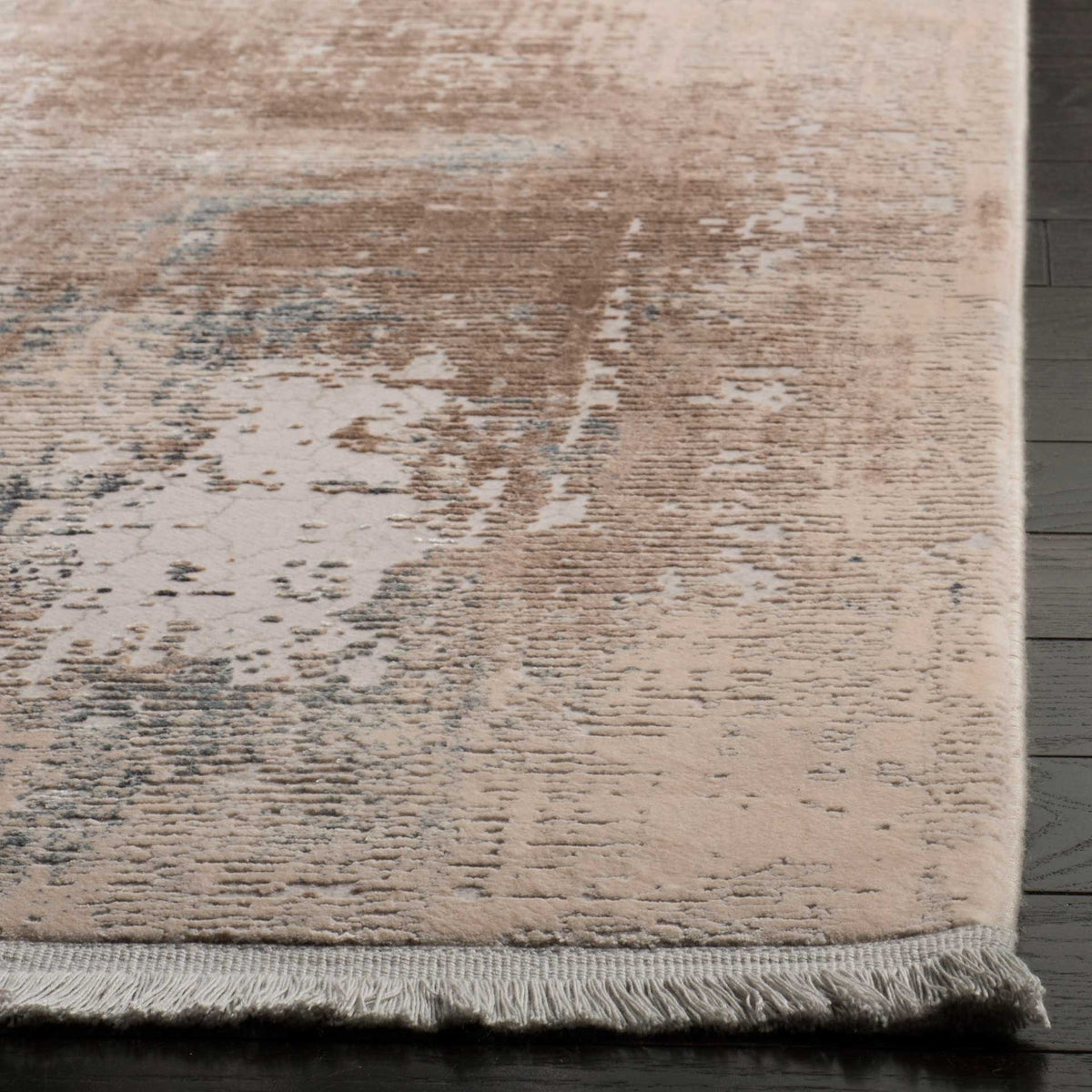 Short fringe finishes the rug's edge beneath a textured blend of beige and muted blue.