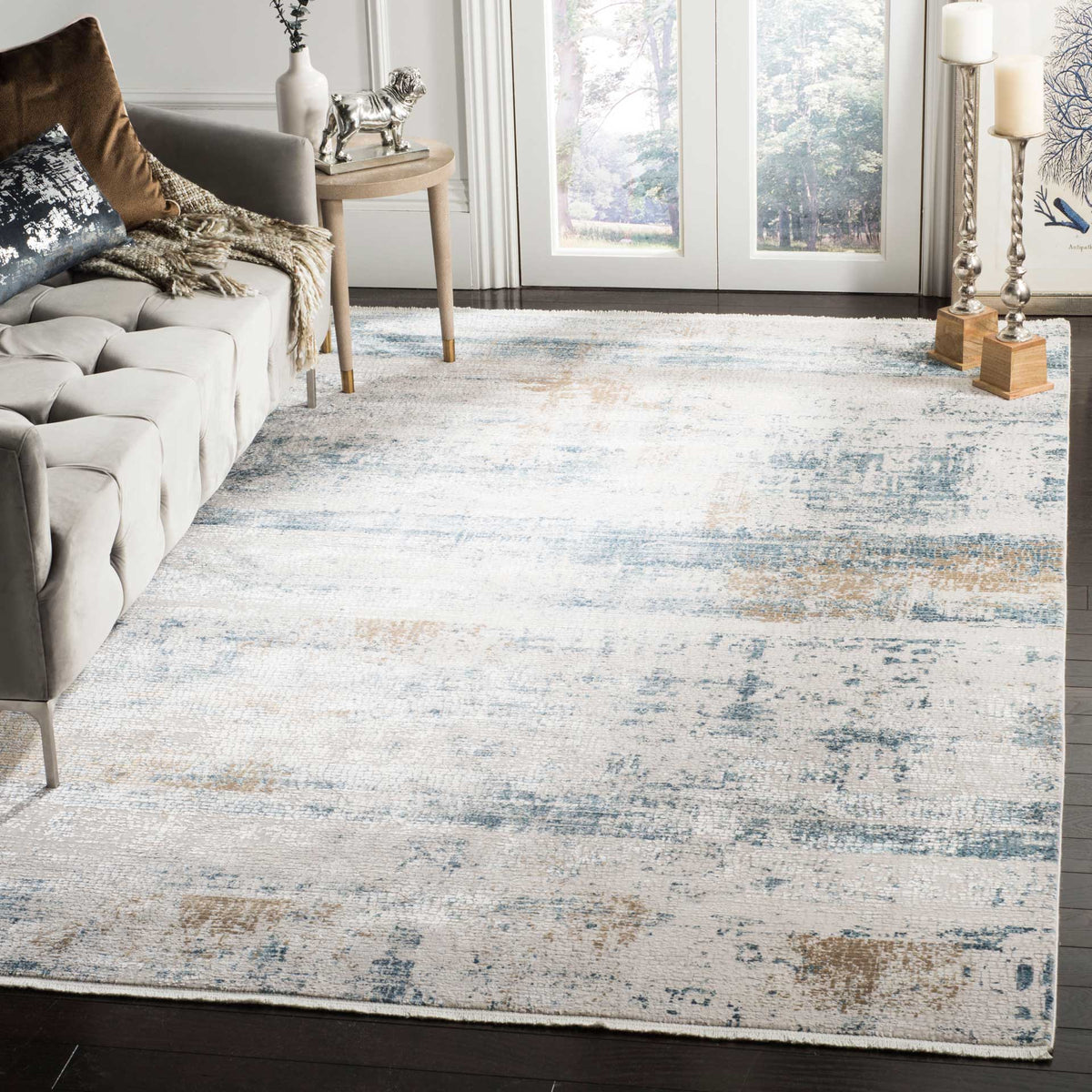 A pale rug with muted blue and taupe accents brings softly distressed character to a living room.
