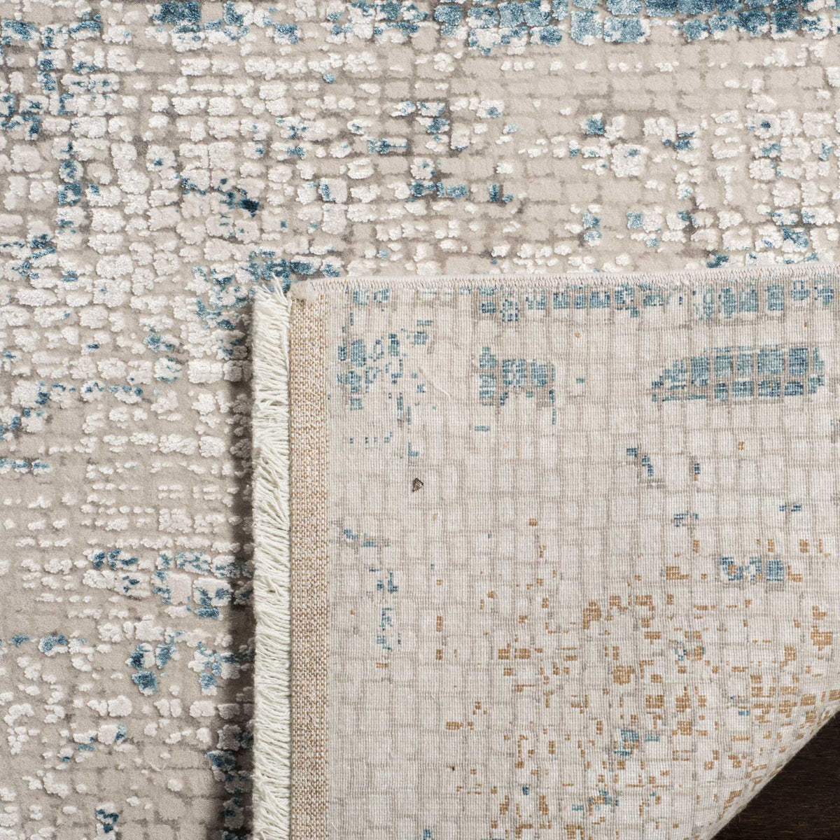 A woven backing and short fringe complement the rug's softly textured abstract surface.