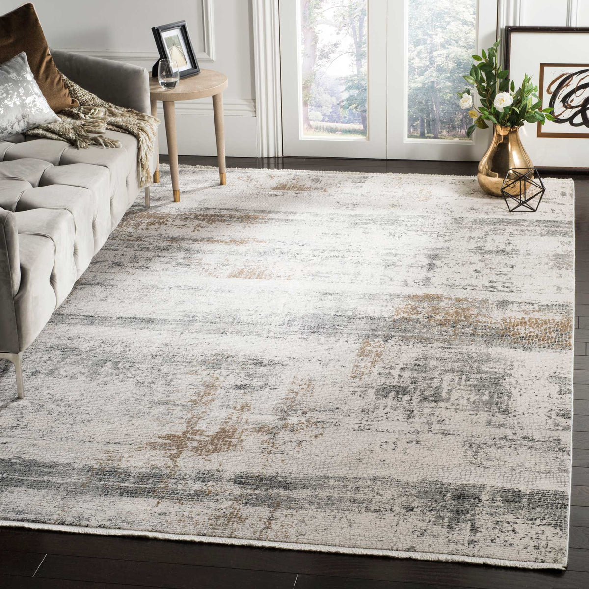 The softly distressed beige and gray rug adds understated pattern beneath living room furnishings.