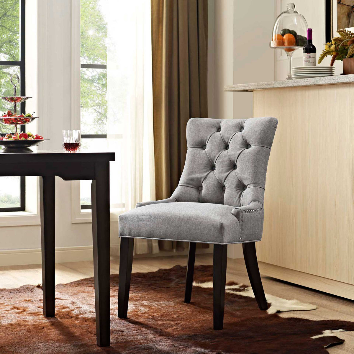 Light gray tufted dining chair offers a plush spot at the table amid warm neutral decor.