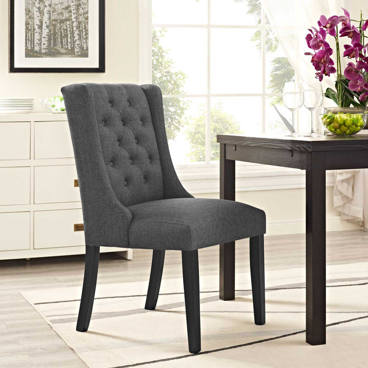 Gray button-tufted dining chair offers plush seating and a graceful silhouette for the dining room