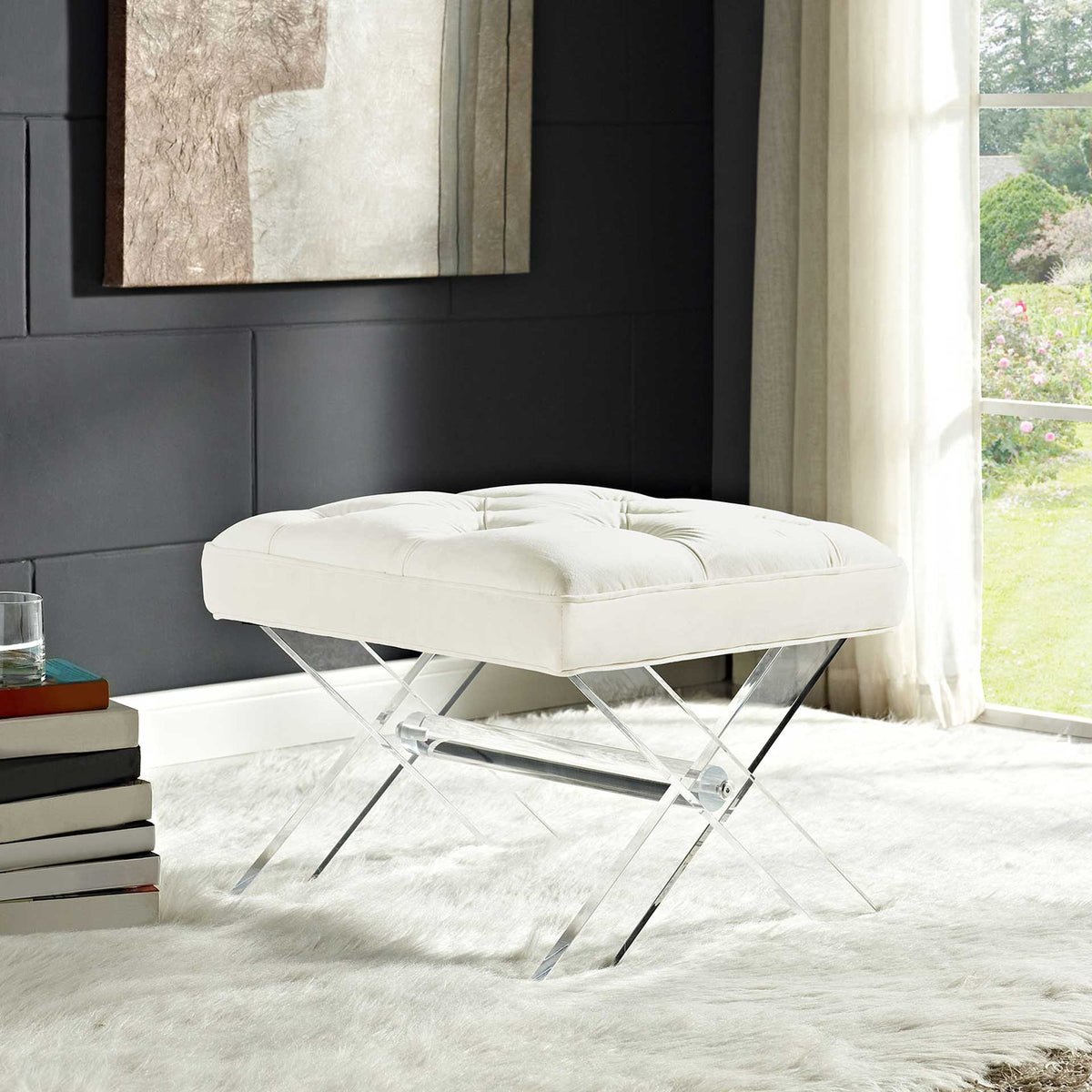 An ivory tufted bench on clear acrylic X-legs adds a soft accent beside a window