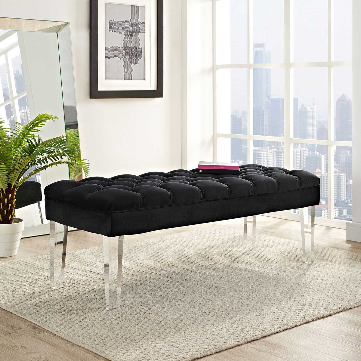 Airy acrylic legs lighten the look of a richly tufted black velvet bench