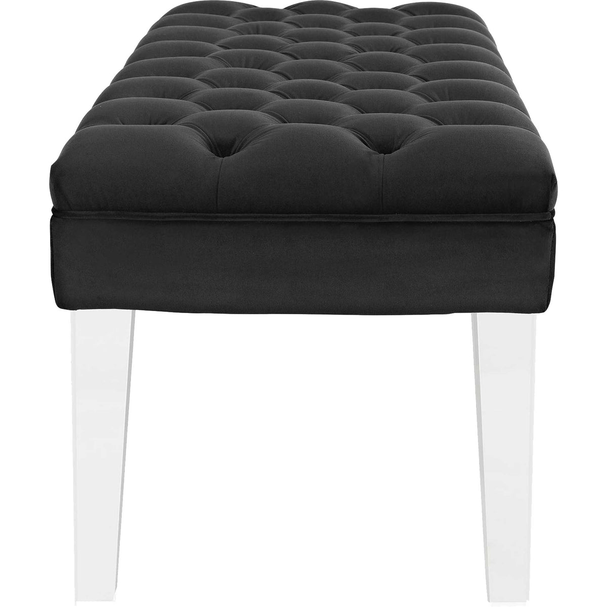 A thick black velvet cushion with button tufting rests on slender, transparent legs