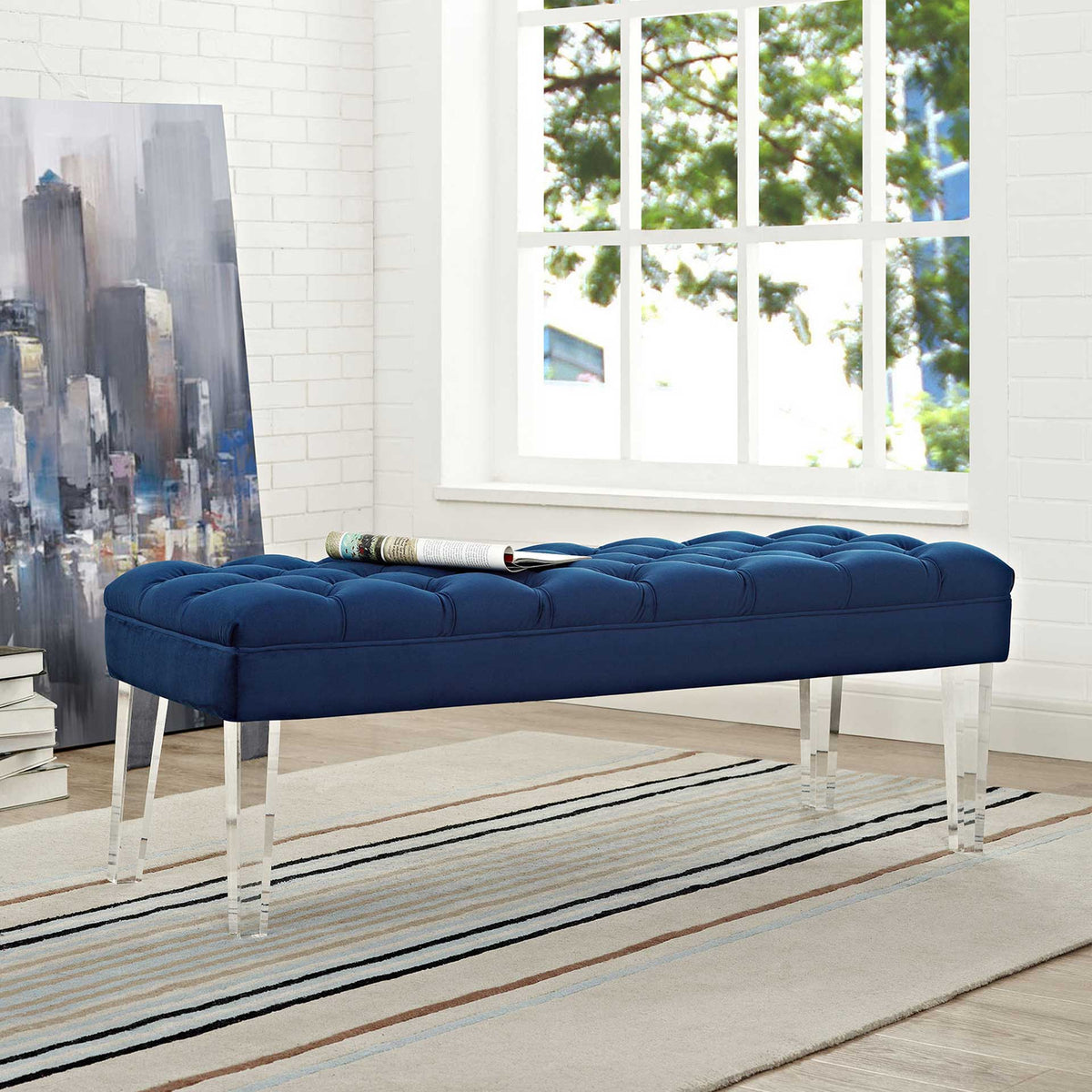 Clear acrylic legs give a deep navy tufted bench a light, modern silhouette