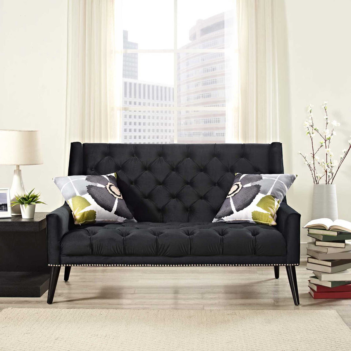 Black velvet loveseat brings plush tufting and tailored nailhead trim to a bright living space