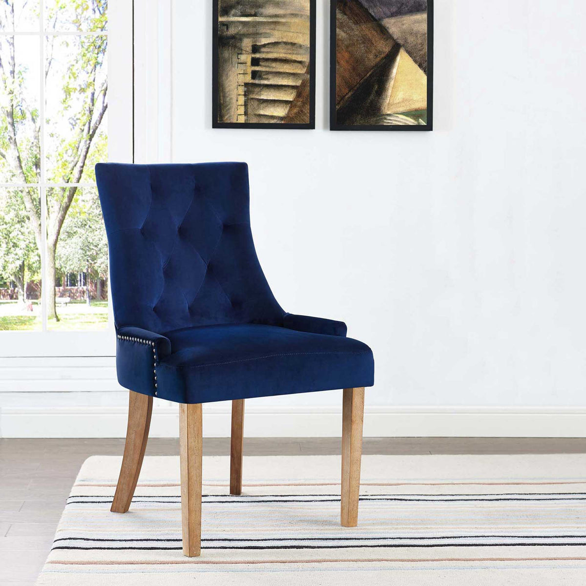 Rich navy velvet, diamond tufting, and light wood legs lend a striking accent to the dining space