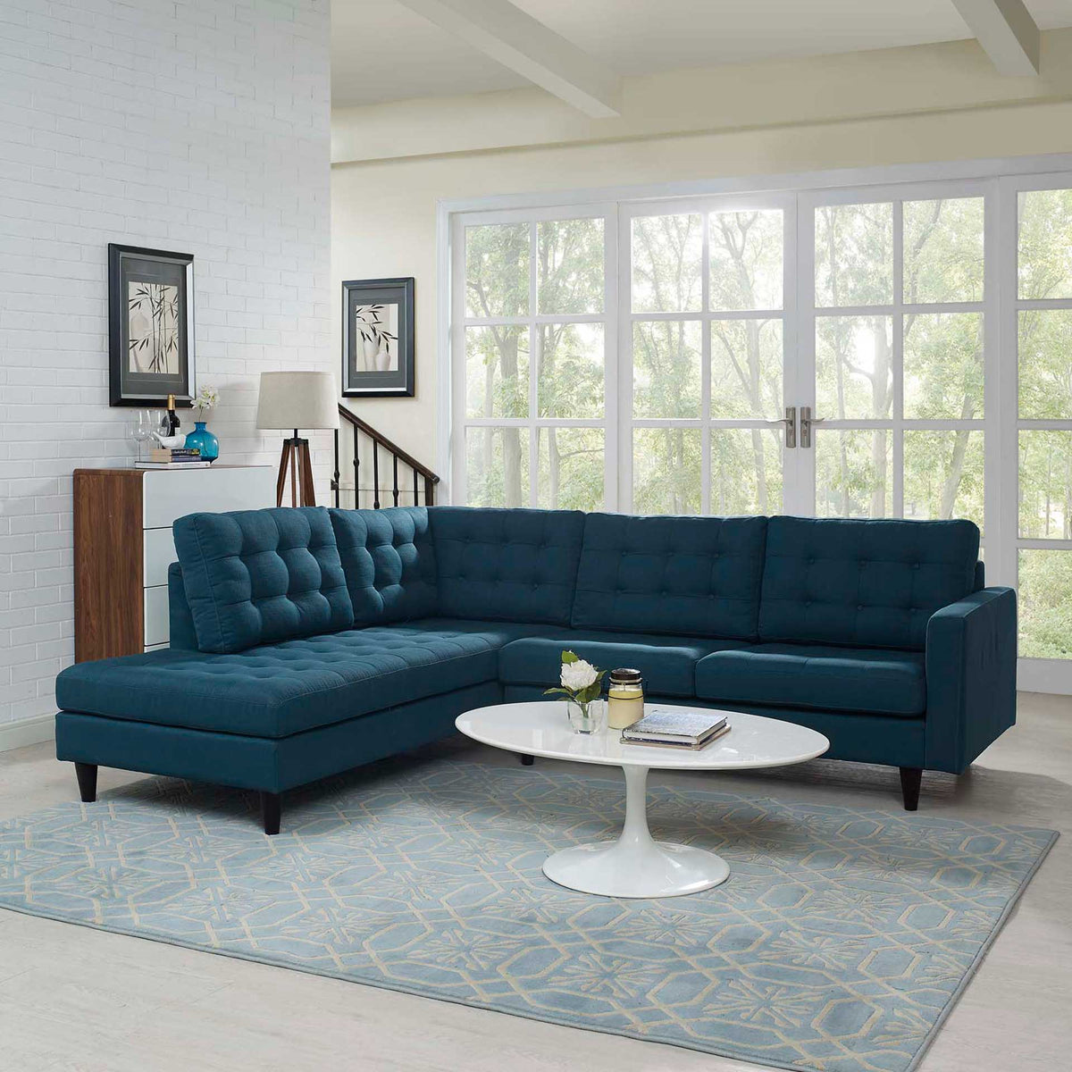 Deep blue sectional sets a roomy chaise beside tufted loveseat seating on tapered legs