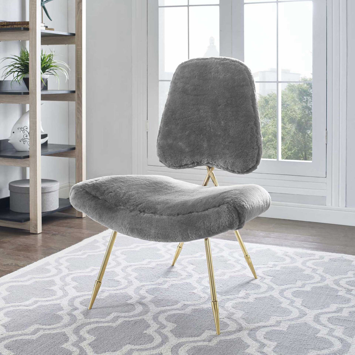 Gray sheepskin and slender gold legs give this sculpted lounge chair a cozy, modern feel.