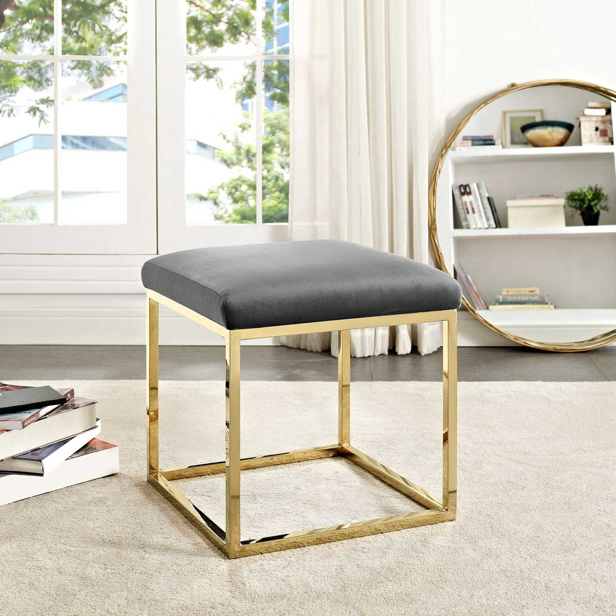 Soft gray velvet and polished gold bring subtle elegance to a sunlit space