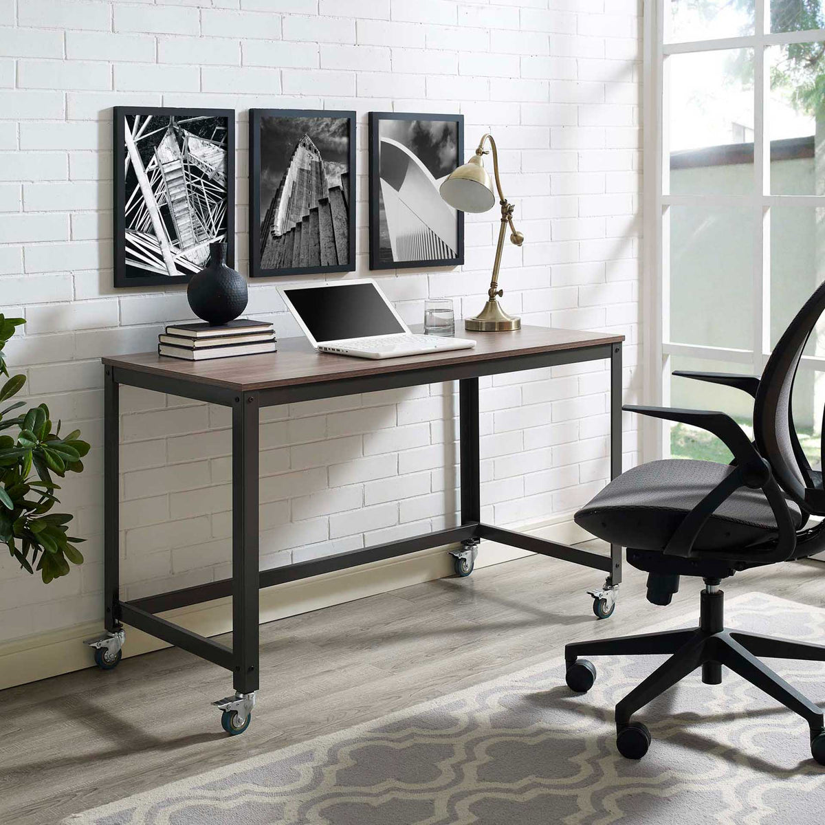 A rolling industrial desk offers ample space for a laptop, lamp and decorative accents