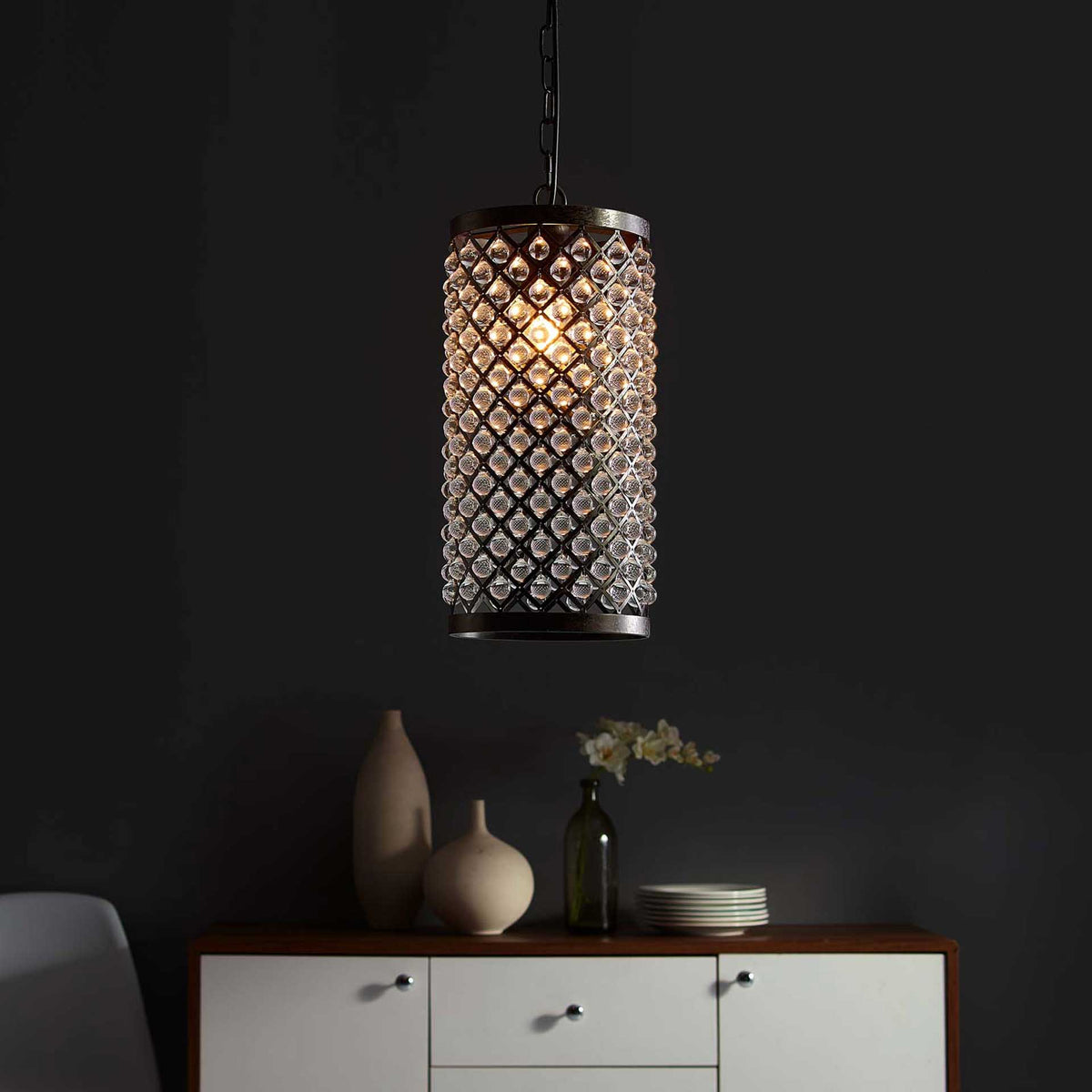 Warm light glows through clear glass beads and the diamond-patterned black metal shade.