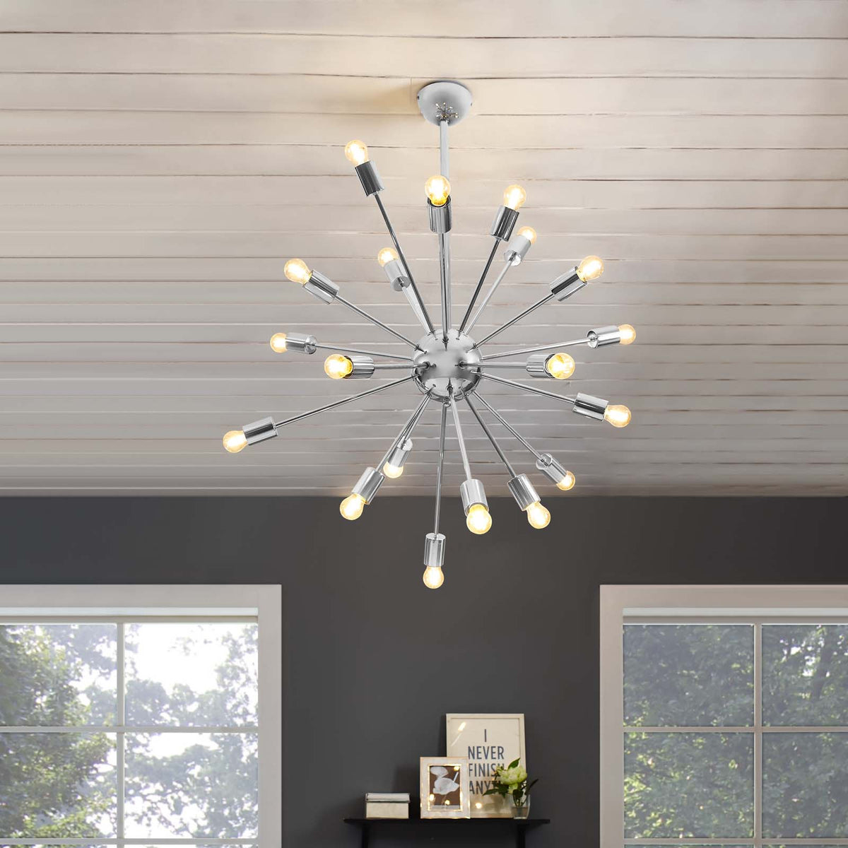 Warmly glowing bulbs radiate from a silver starburst chandelier, brightening a modern interior
