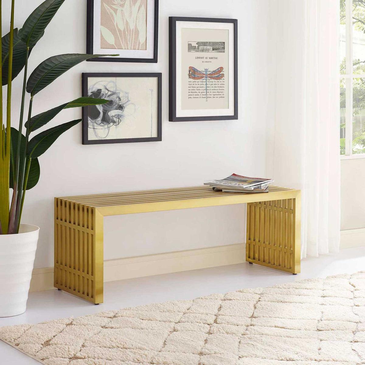 The gold slatted bench brings warm metallic color and airy lines to a bright living space.