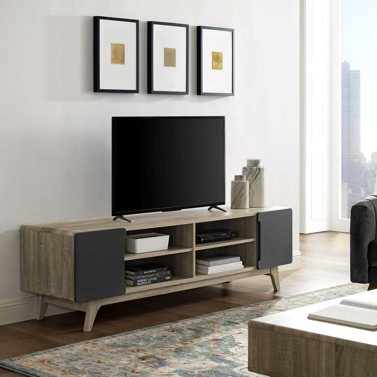 Gray cabinet doors and four open cubbies organize media beneath a TV on the wood-grain console.