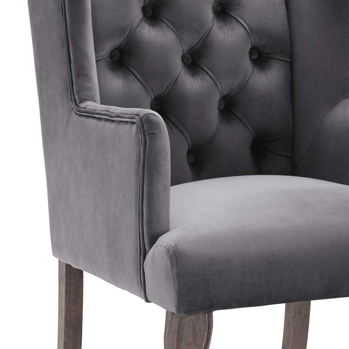 Soft gray velvet, deep button tufting, and fine piping frame a generously cushioned seat