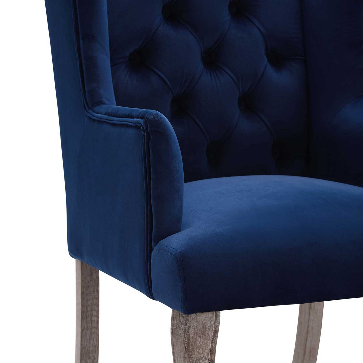 Navy velvet, deep button tufting, and crisp piping give the plush seat a tailored look
