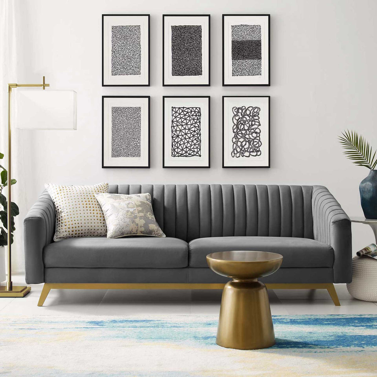 Plush gray velvet sofa adds sculptural vertical tufting and warm gold accents to a living space