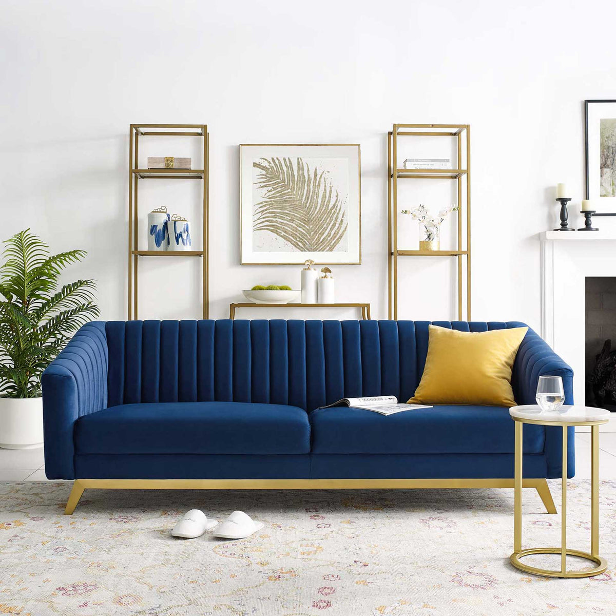 Navy velvet sofa brings deep blue color, vertical channel tufting, and gold trim to the living room