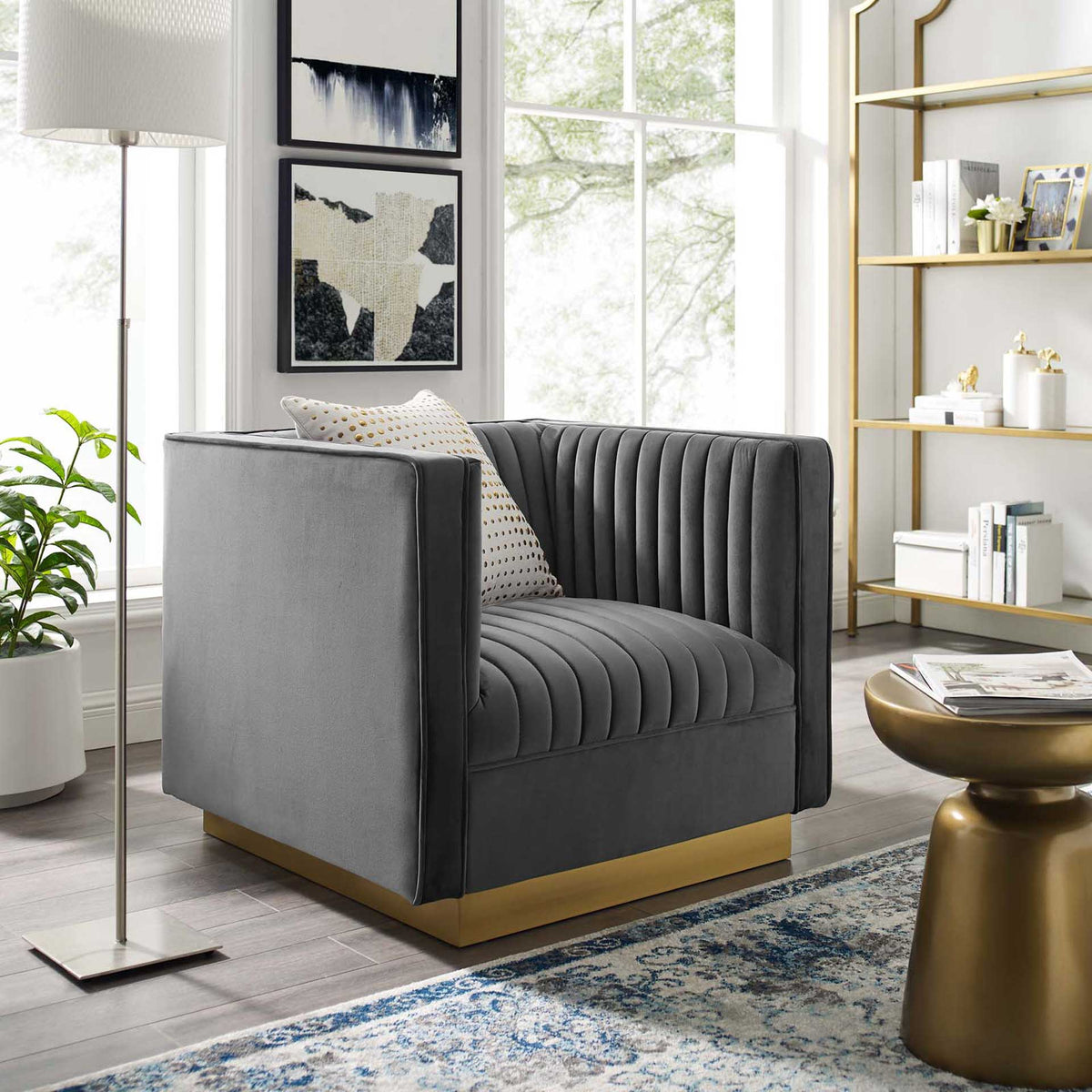 A plush gray velvet chair with channel tufting and a gold base adds inviting comfort to modern decor