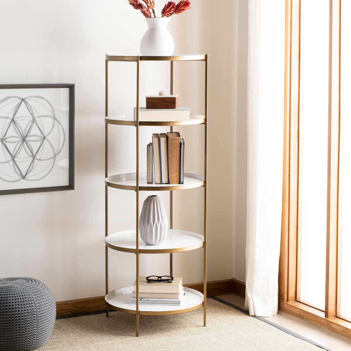 Books and decor rest on five white round shelves within an airy brass-finished frame.