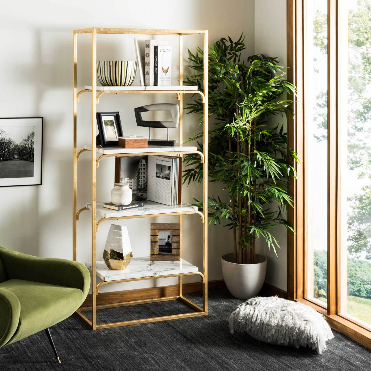 White marble-look shelves display books, artwork, and decorative accents within a warm gold frame.