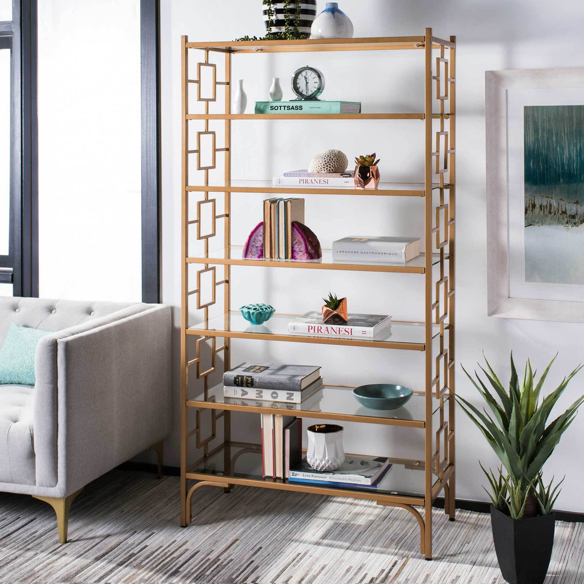 Gold and glass etagere displays books, plants and decorative accents across seven shelves