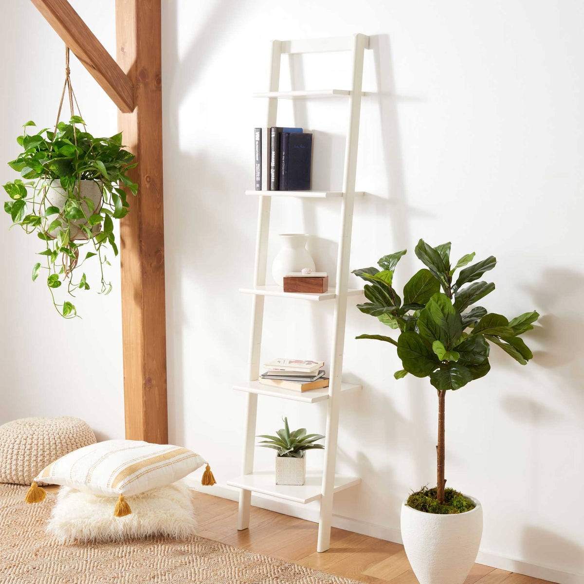 White leaning shelves display books and plants with a clean, airy feel