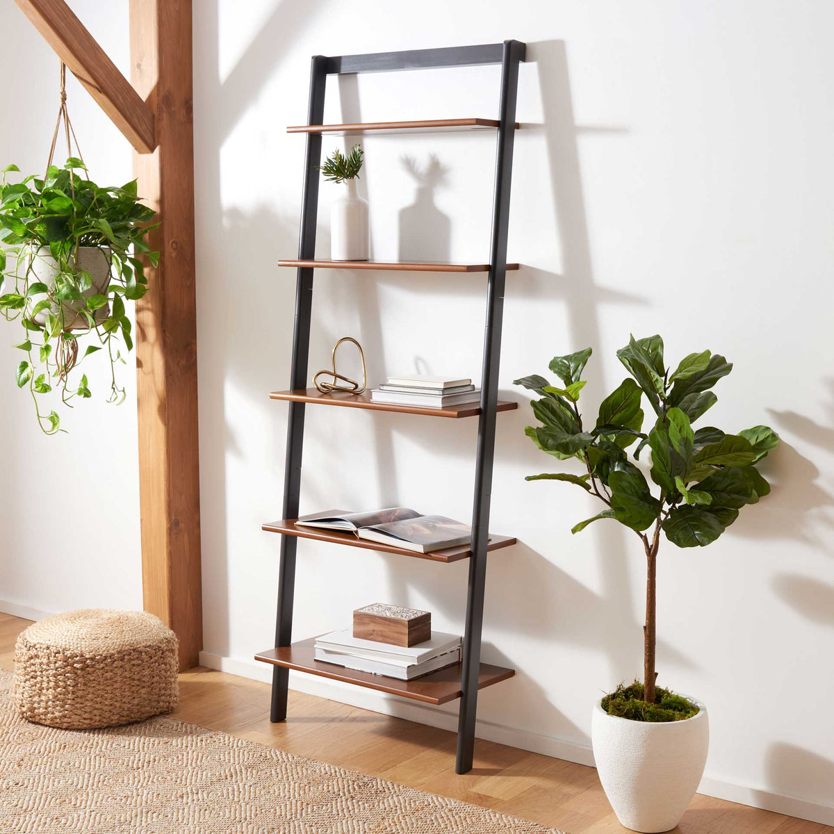 Honey-brown shelves hold books and decor against a slim charcoal frame.