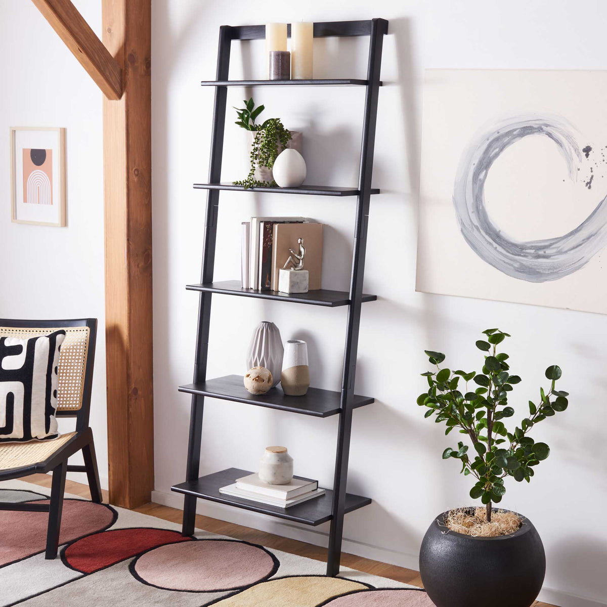 Black leaning shelves display books, vases and greenery in a compact footprint.