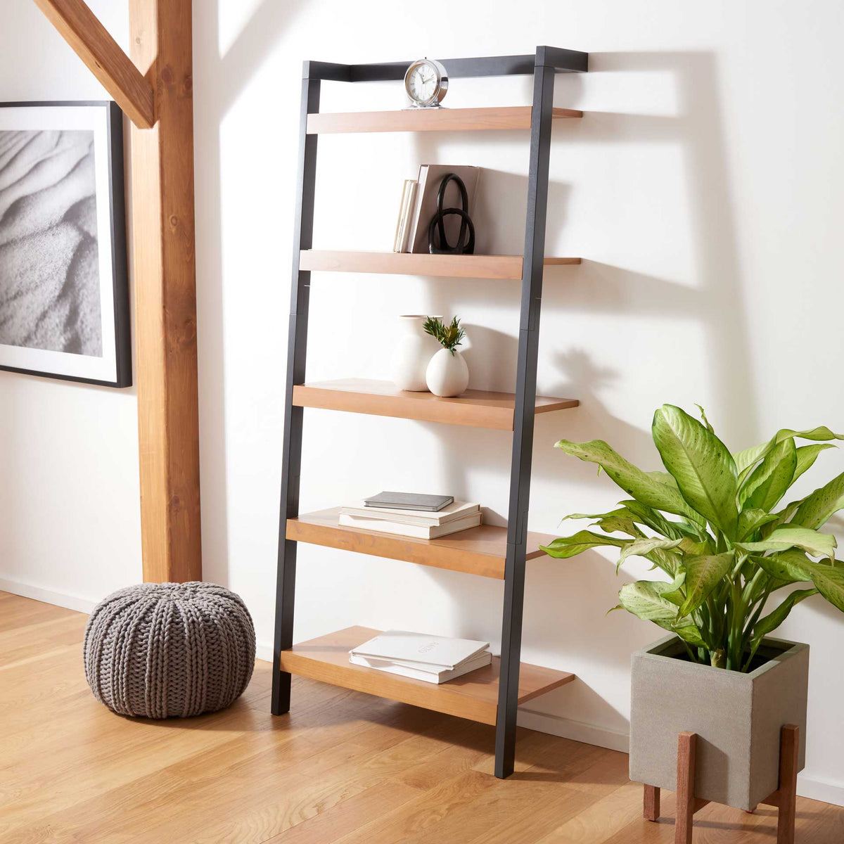 Natural wood shelves and a charcoal frame display books and accents in a warm, open layout.