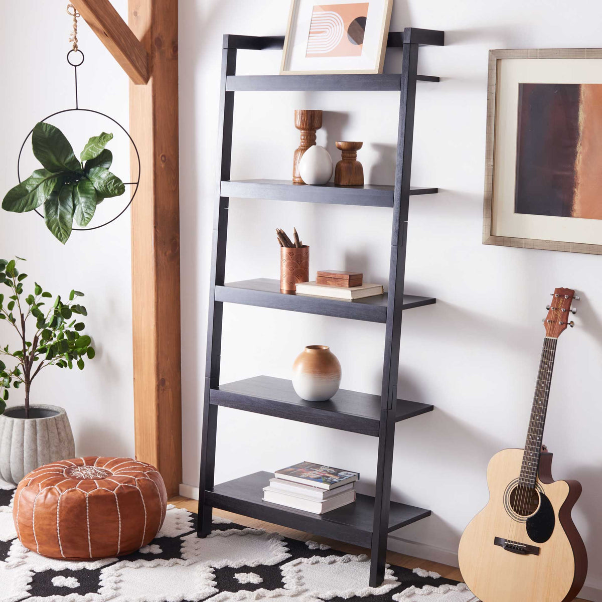 A black leaning bookcase brings five tiers of display space to books and decorative objects.
